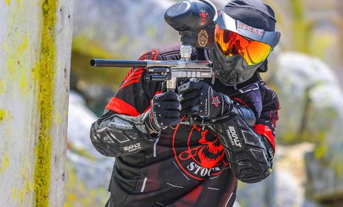 Speedball player on a fixed-bunker field — mirrored competitive paintball